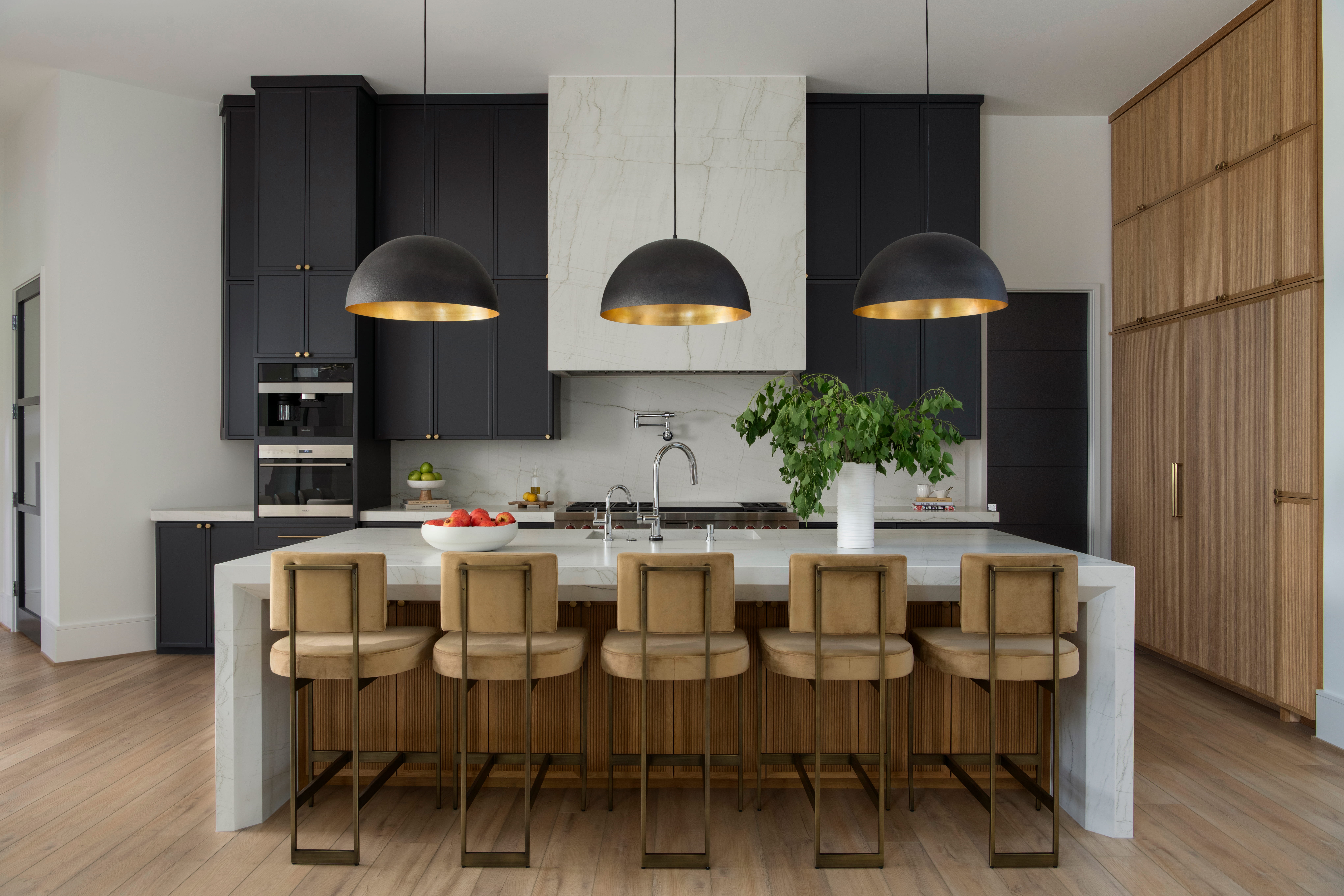Modern custom kitchen with oversized island, built-in storage, and family seating for meals and gatherings