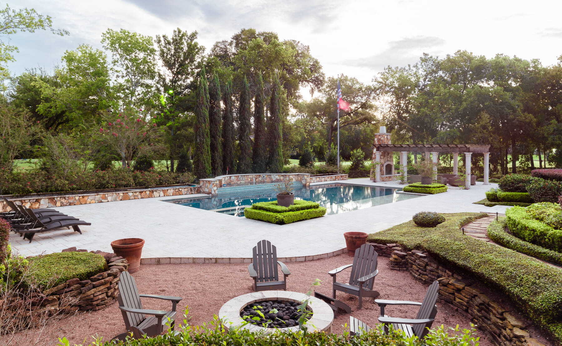 Custom backyard with pool, fire pit, pergola, and outdoor gathering spaces for family living