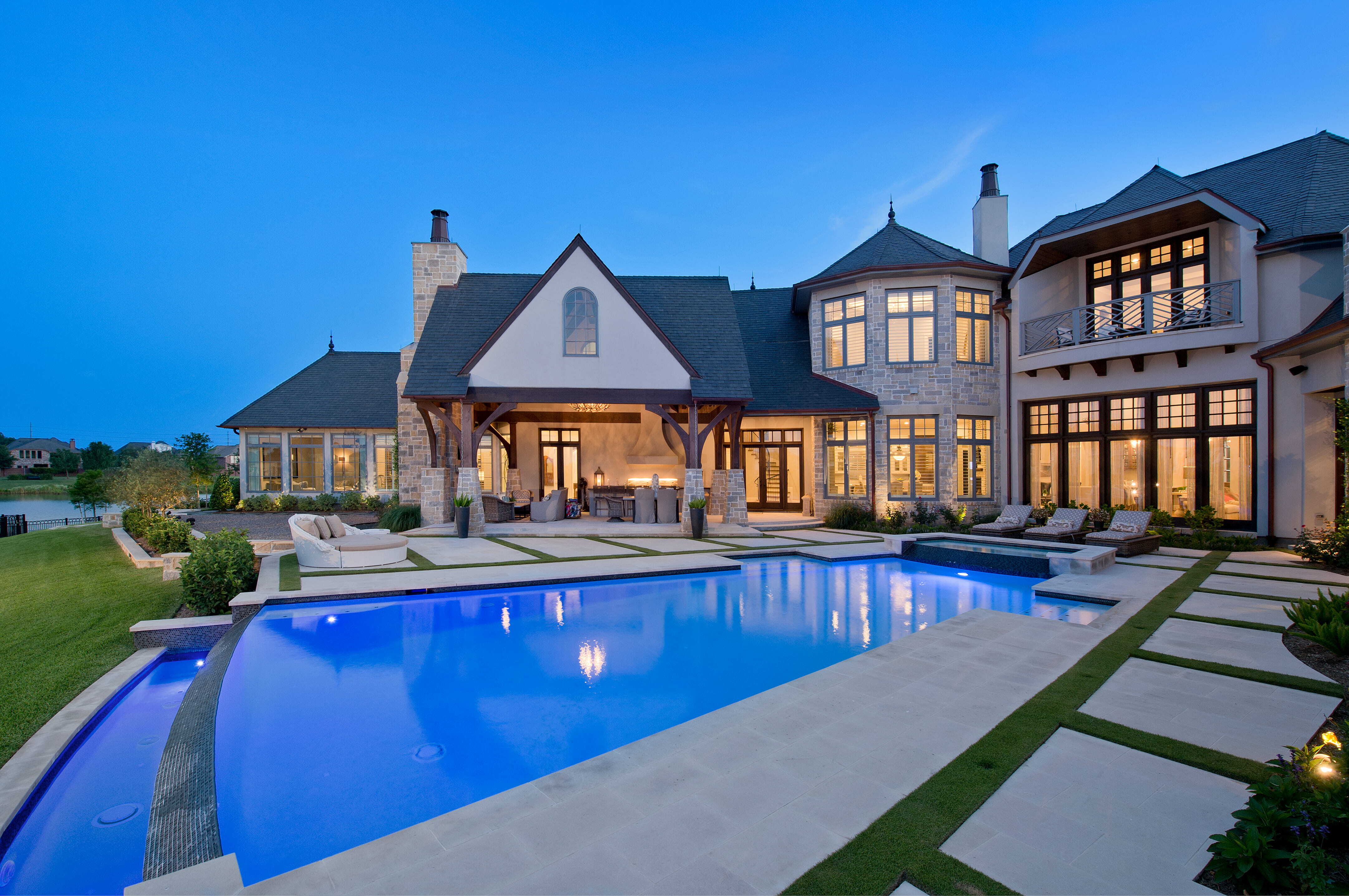 Family-friendly custom home backyard with pool, covered patio, outdoor seating, and landscaped lawn