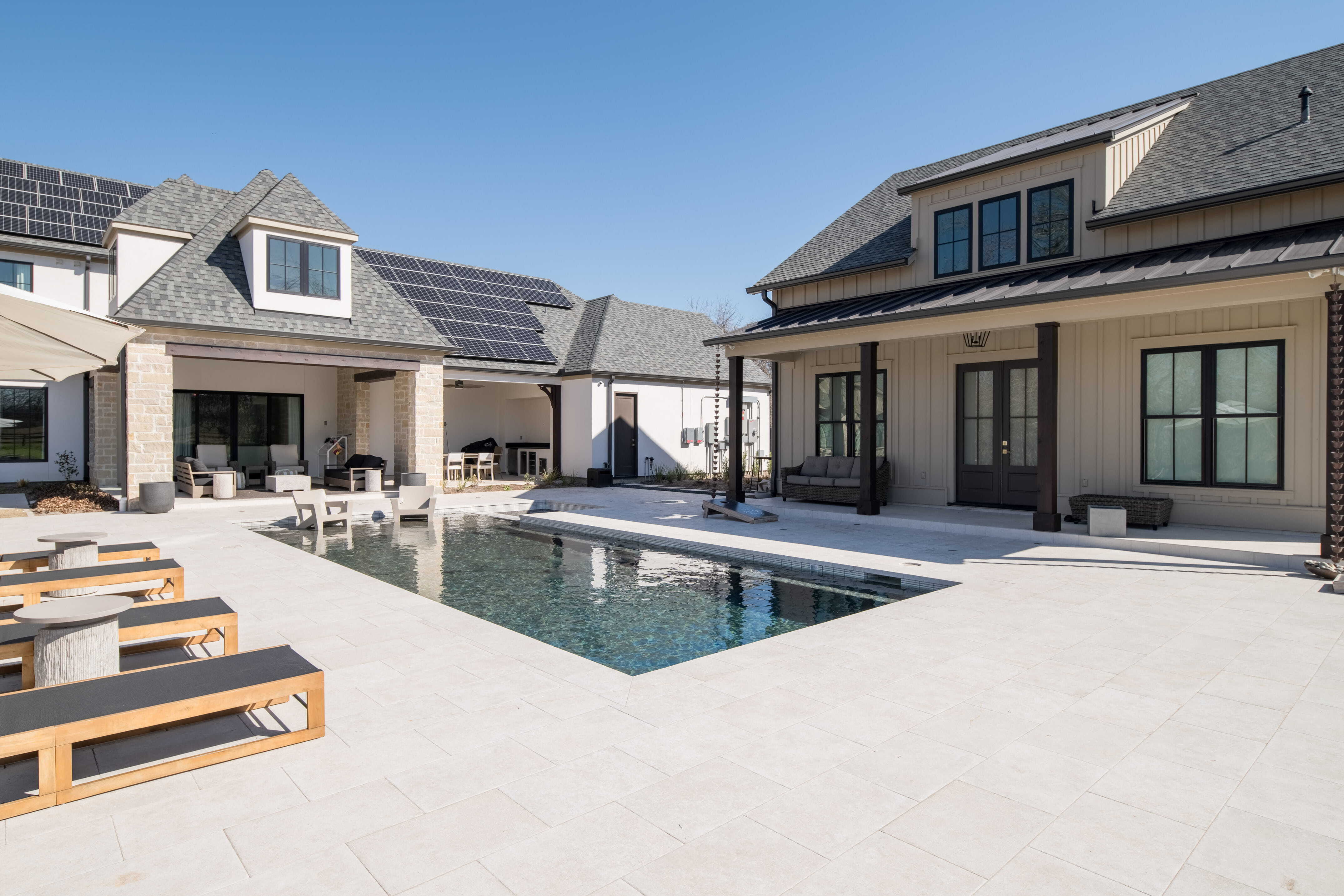 Energy-efficient custom home with solar panels, pool, outdoor living areas, and family-friendly backyard design