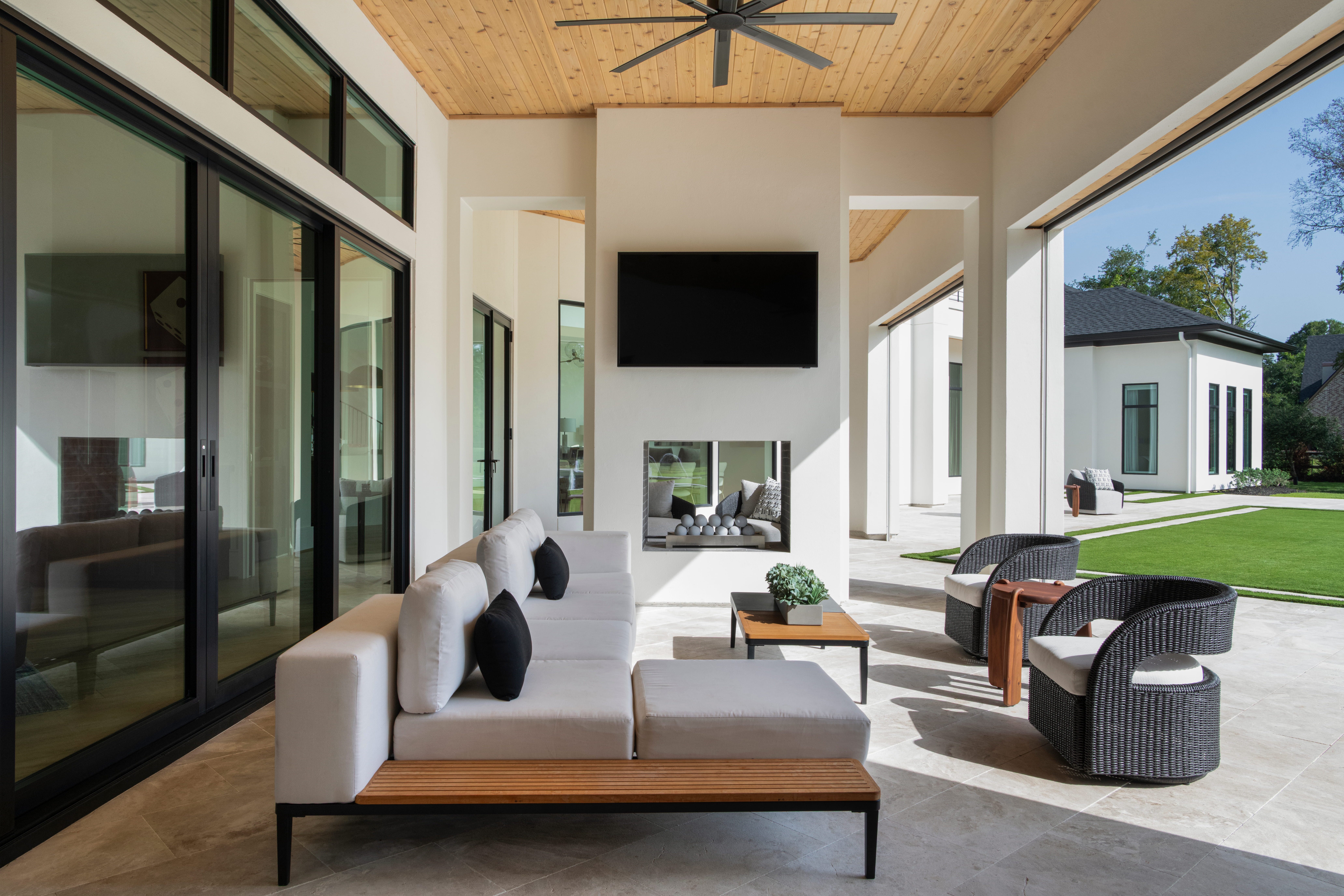 Covered outdoor living space with large sliding doors, natural light, and energy-efficient custom home design