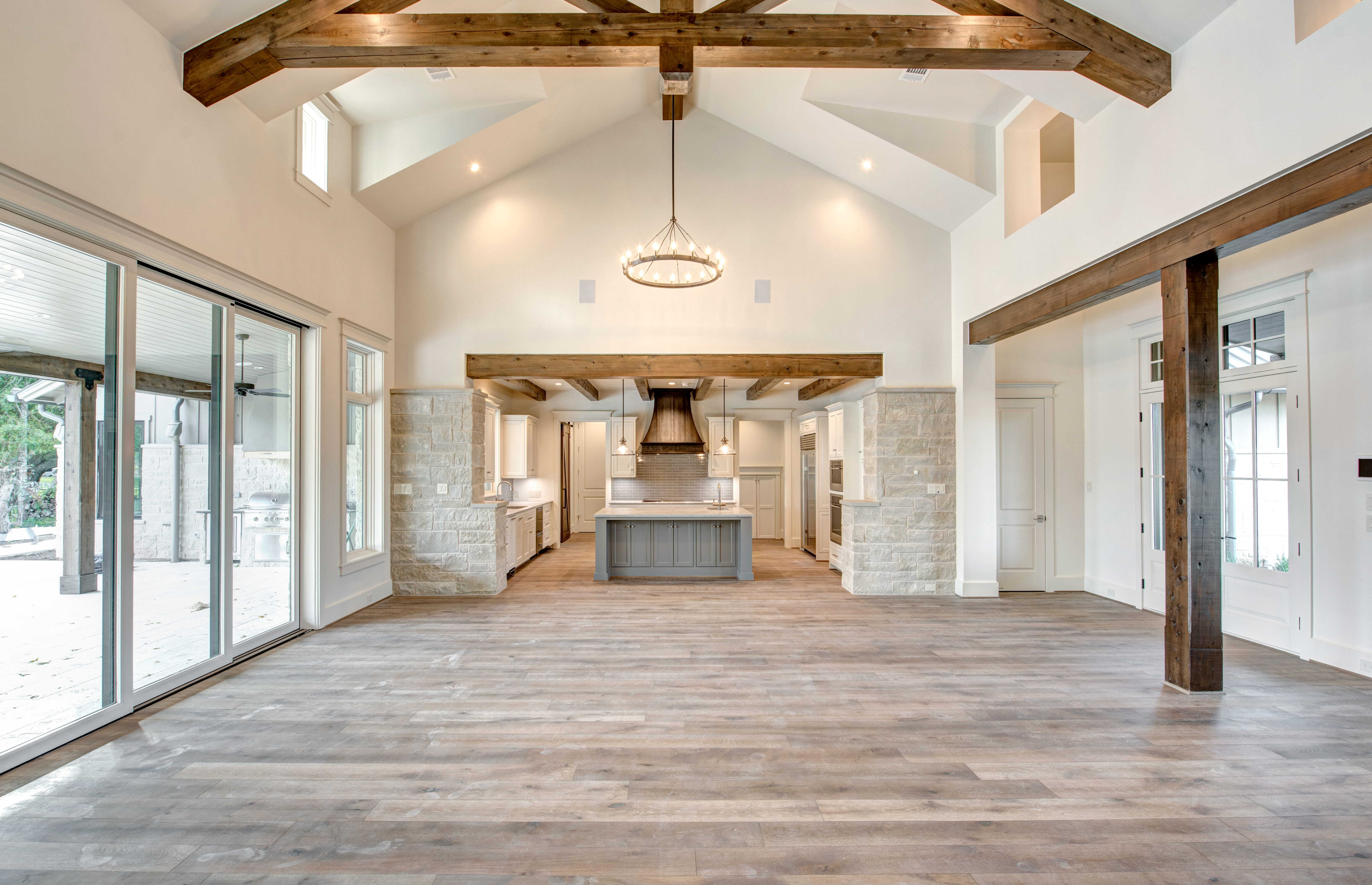 Energy-efficient custom home interior with open floor plan, vaulted ceiling, natural light, and connected kitchen