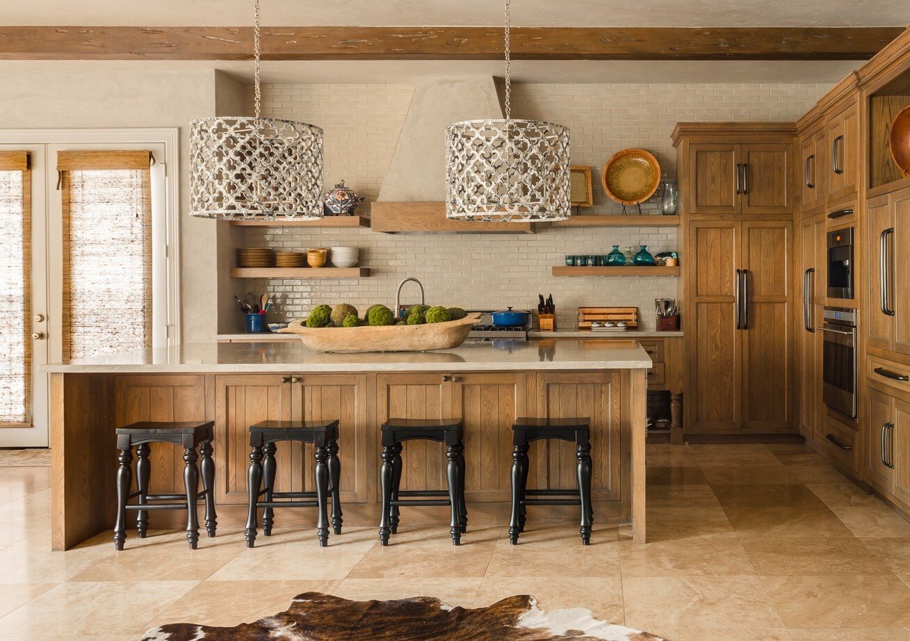 Luxury custom home kitchen with wood cabinetry, large island, open shelving, and statement pendant lighting.
