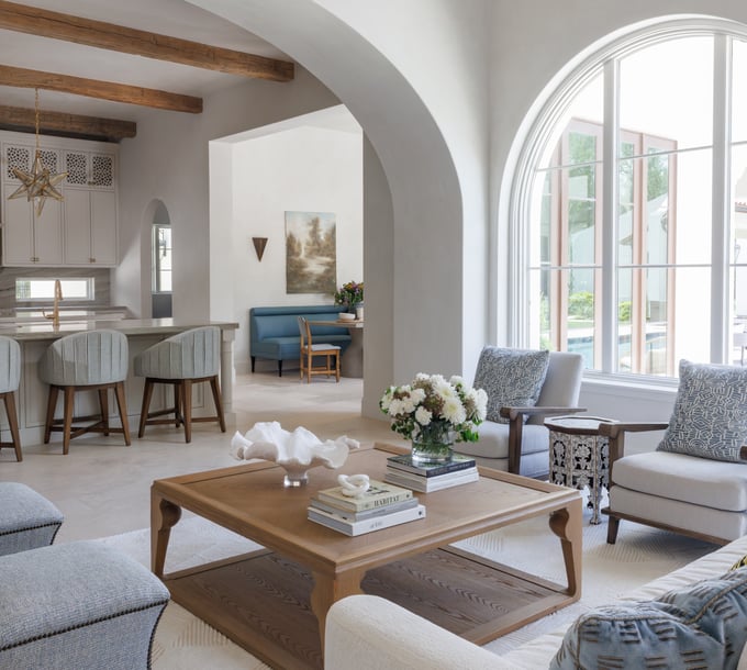 Arched living room in a luxury custom home with soft neutral finishes, wood accents, and layered interior design details.