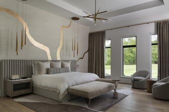 Primary bedroom with gold accent wall, pendant lighting, upholstered bed, and large windows facing the backyard.