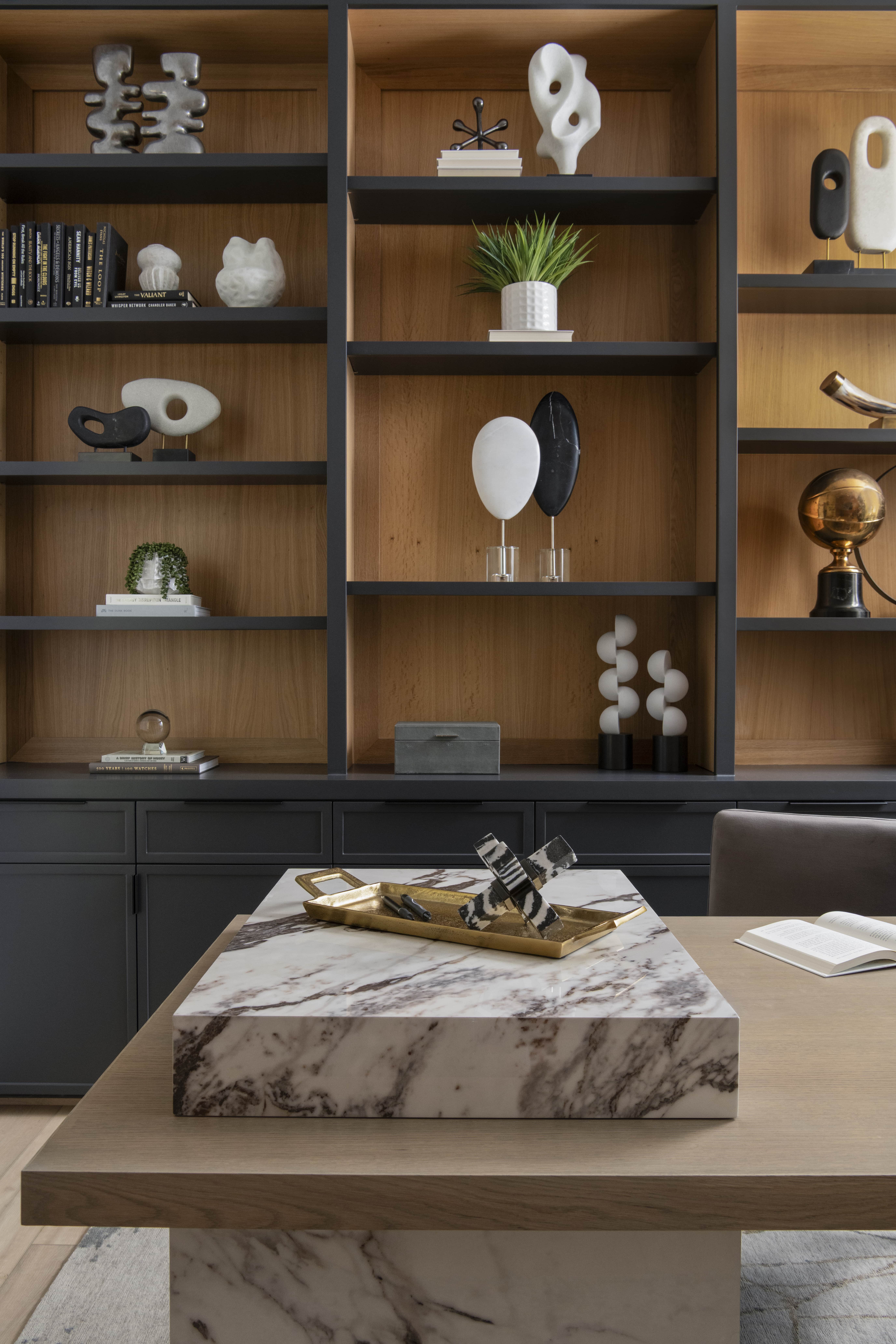 Close-up of modern built-ins showcasing curated sculptures and décor in a warm wood and charcoal palette.