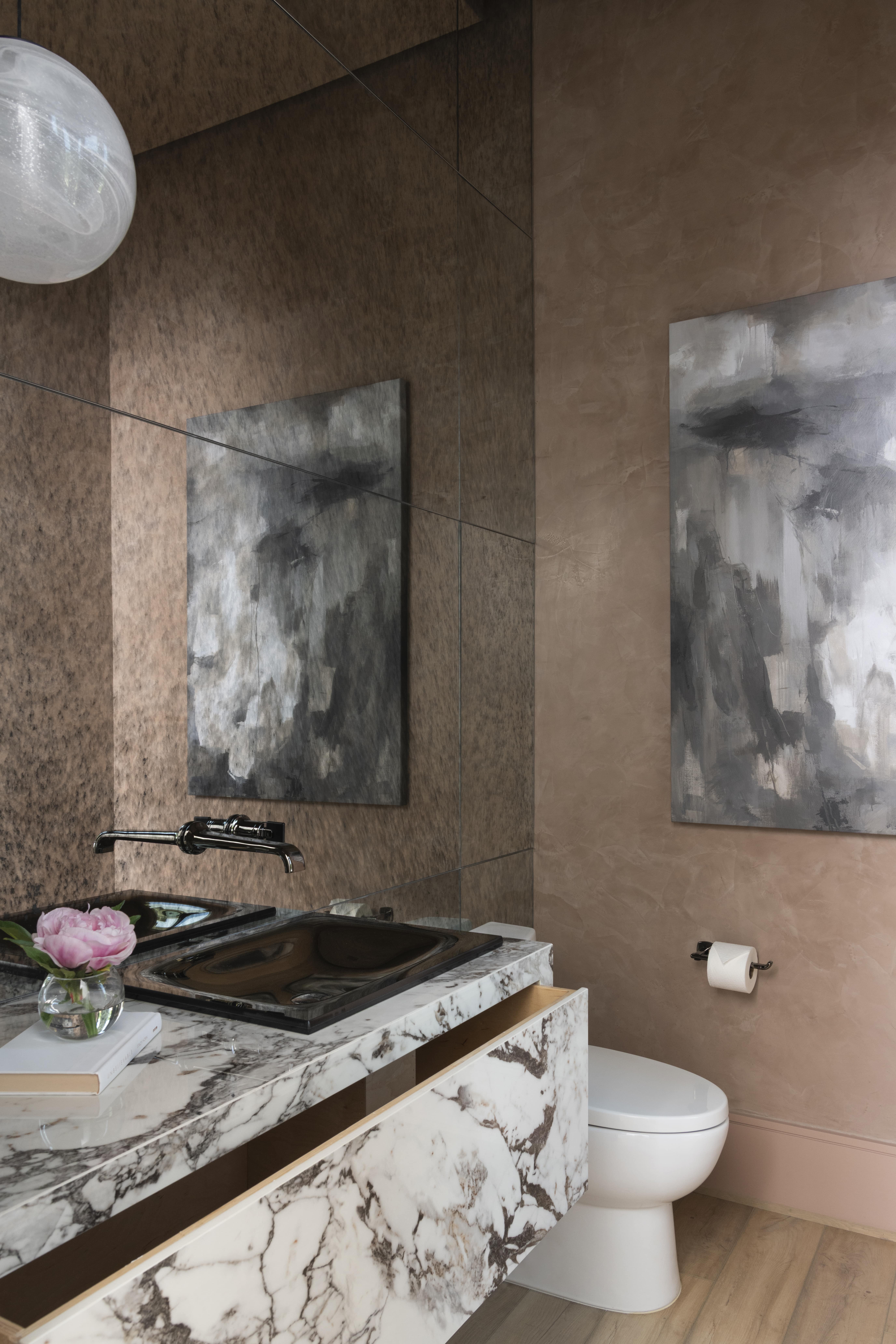 Powder bath featuring a marble floating vanity with open drawer and textured plaster walls.